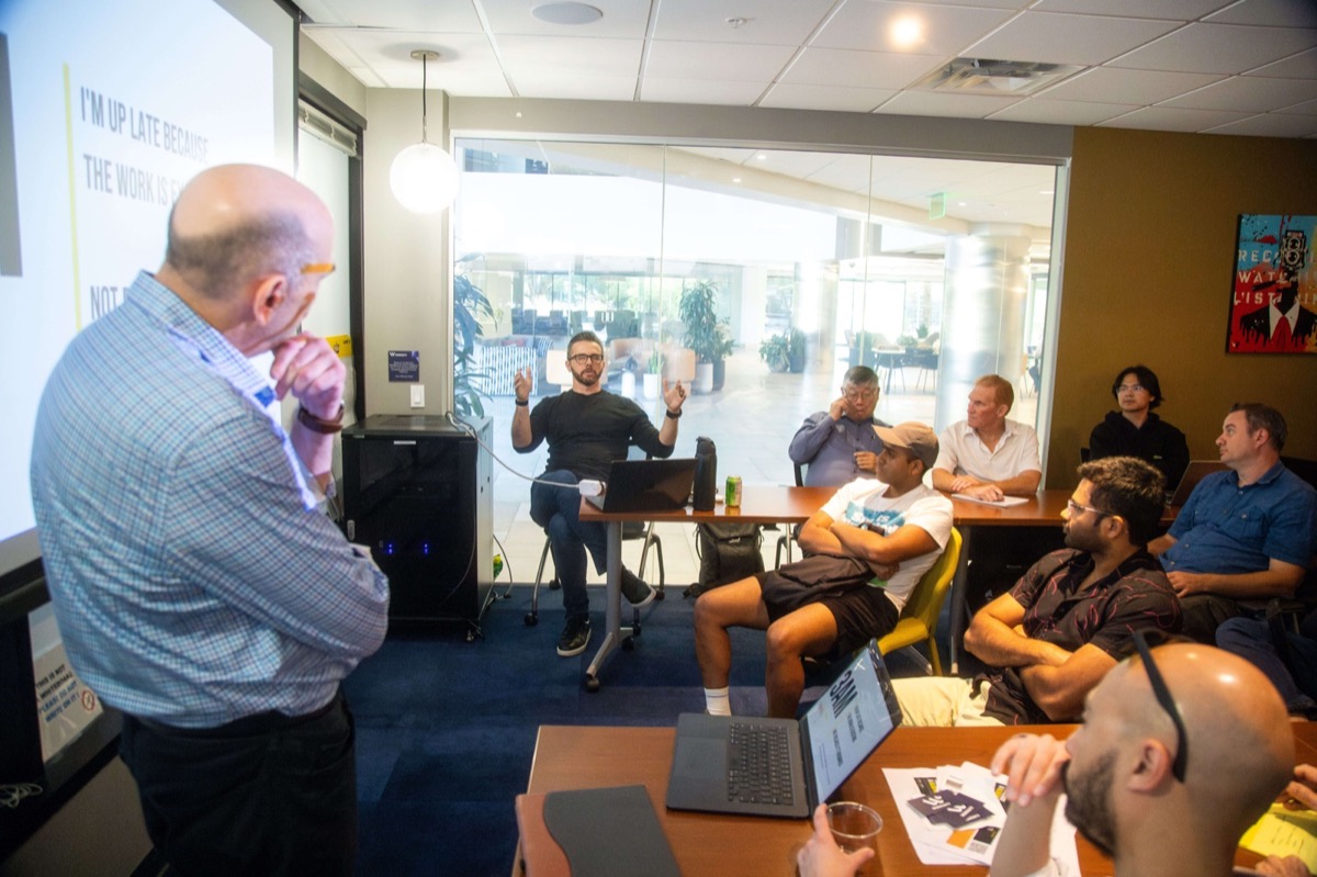 A speaker presenting to a room of builders at an AI Launch hackathon